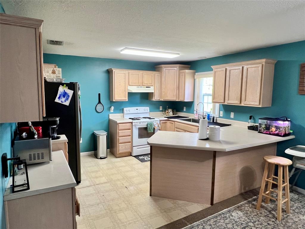 8971 Southeast 67th Drive Okeechobee, FL 34974 - Photo 6 of 14 a kitchen that has a sink and a stove in it