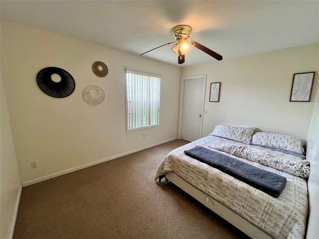 8971 Southeast 67th Drive Okeechobee, FL 34974 - Photo 10 of 14 a spacious bedroom with a bed and a chandelier