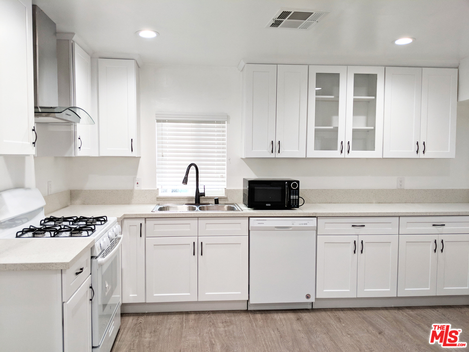 a kitchen with white cabinets and appliances