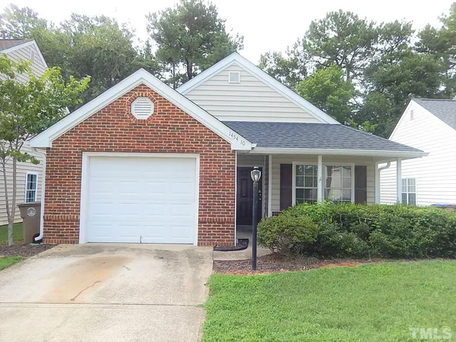 a front view of a house with a garden and plants