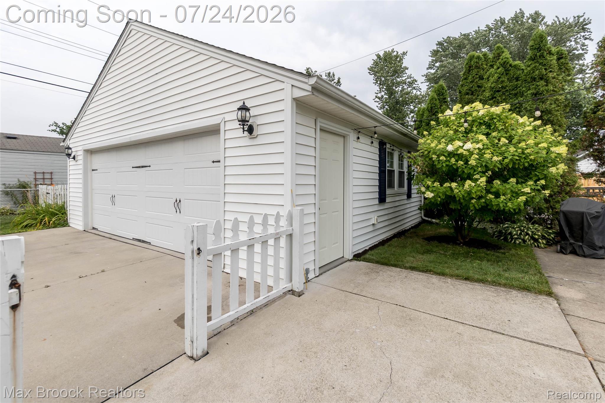 1090 Cambridge Road Berkley, MI 48072 - Photo 35 of 43 Detached two-car garage with white siding and black garage door hardware