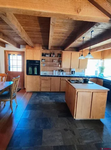 a room with wooden floors and kitchen view