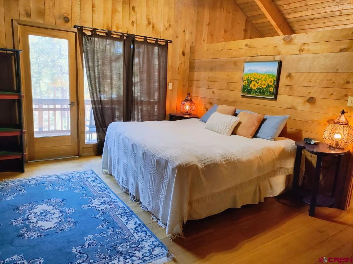 360 Sortais Road Durango, CO 81301 - Photo 22 of 36 a bedroom with a bed lamp and a large window