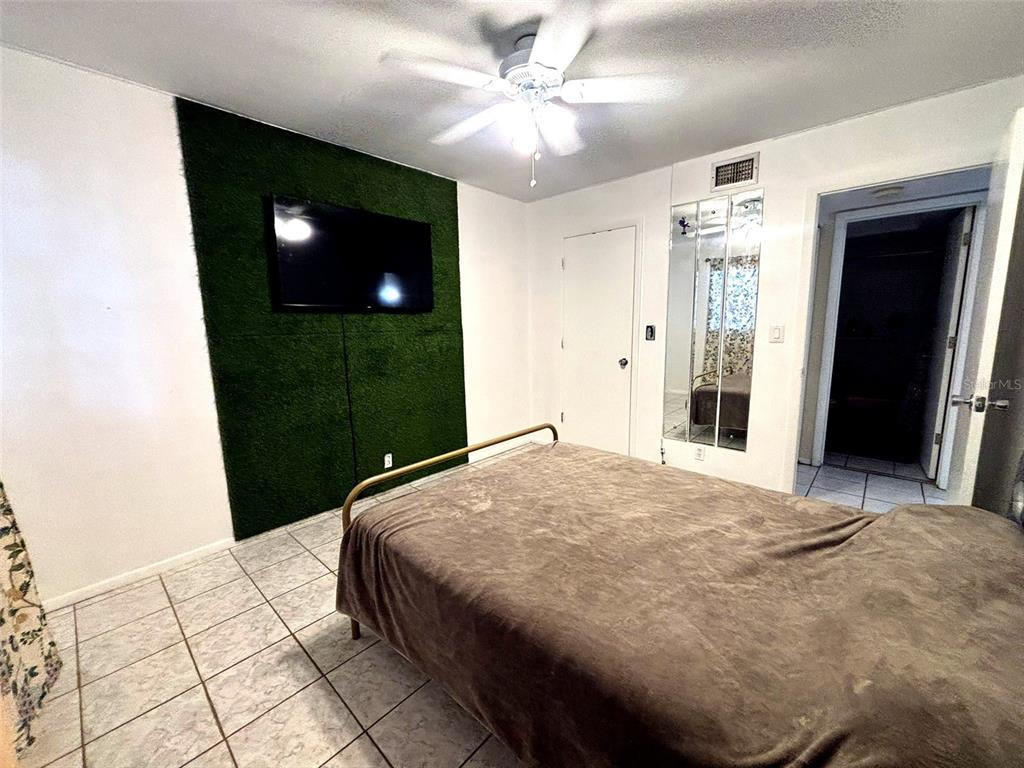 1433 South Belcher Road, Unit B2 Clearwater, FL 33764 - Photo 13 of 20 a bedroom with a bed and a flat screen tv