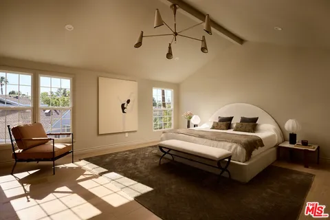 a spacious bedroom with a bed a couch and dresser