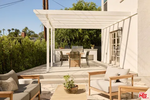a view of a patio with couches table and chairs and potted plants
