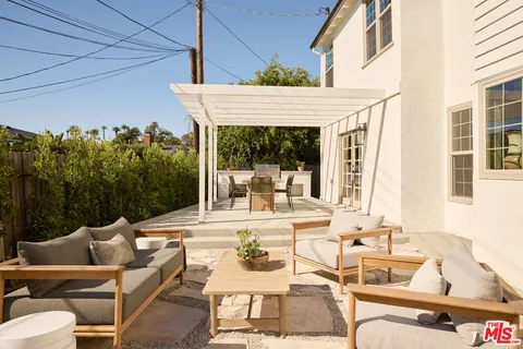 a view of a patio with couches table and chairs and potted plants