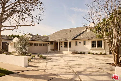 a front view of a house with a yard covered with snow
