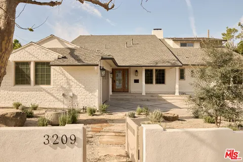 a view of a patio with couches table and chairs and potted plants