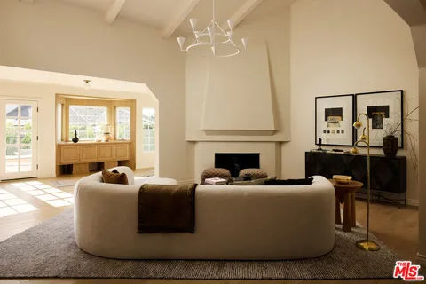 a living room with furniture a fireplace and a chandelier