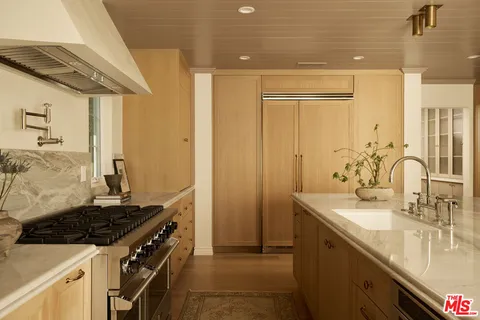 a kitchen with sink stove and cabinets