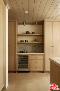 a kitchen with granite countertop white cabinets and wooden floors