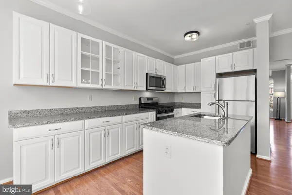 a kitchen with granite countertop white cabinets and a sink