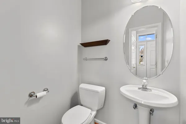 a bathroom with a toilet a sink and mirror