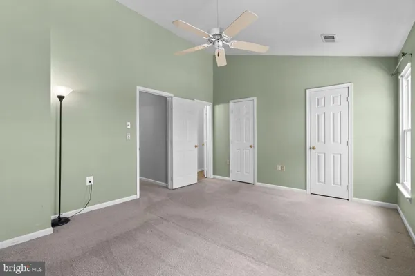 a view of a room with a ceiling fan and a window