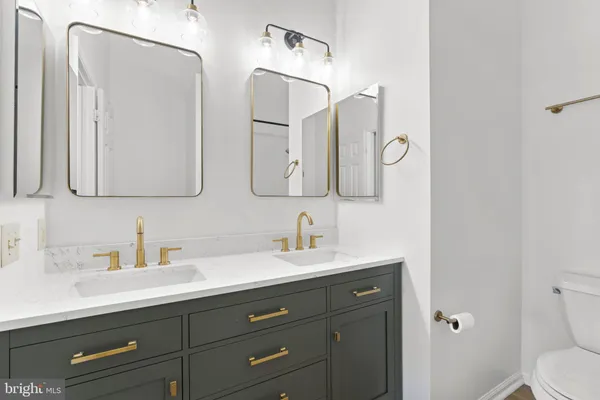 a bathroom with a double vanity sink mirror and toilet