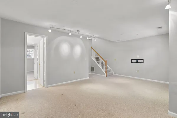 an empty room with stairs and windows