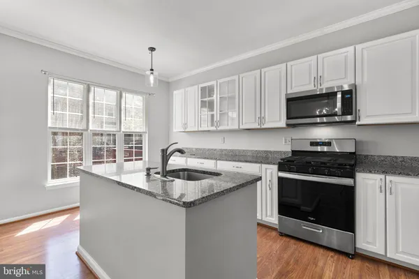 a kitchen with granite countertop a sink and a stove top oven
