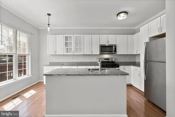 a kitchen with granite countertop a refrigerator and a stove top oven
