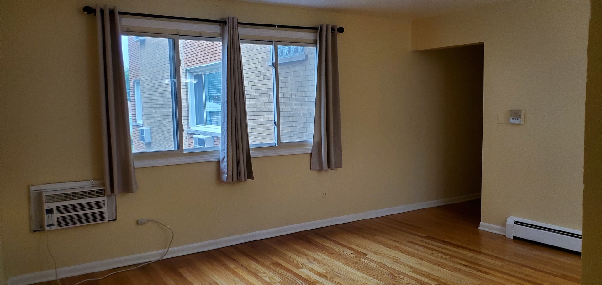 1619 West Howard Street, Unit B3 Chicago, IL 60202 - Photo 2 of 13 a view of an empty room with wooden floor and a window