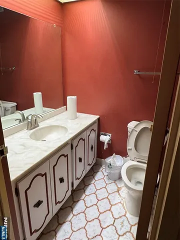 a bathroom with a toilet a sink and mirror