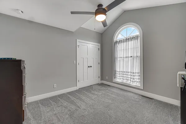 an empty room with windows and ceiling fan