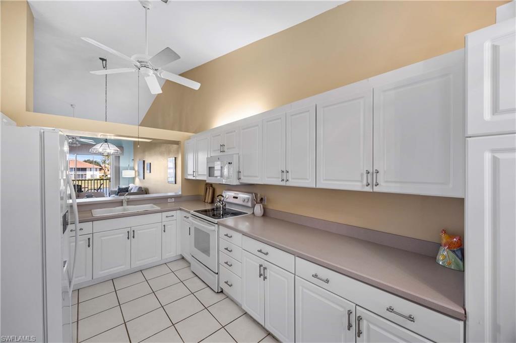290 Robin Hood Circle, Unit 201 Naples, FL 34104 - Photo 11 of 34 a kitchen with cabinets appliances a sink and a counter top space