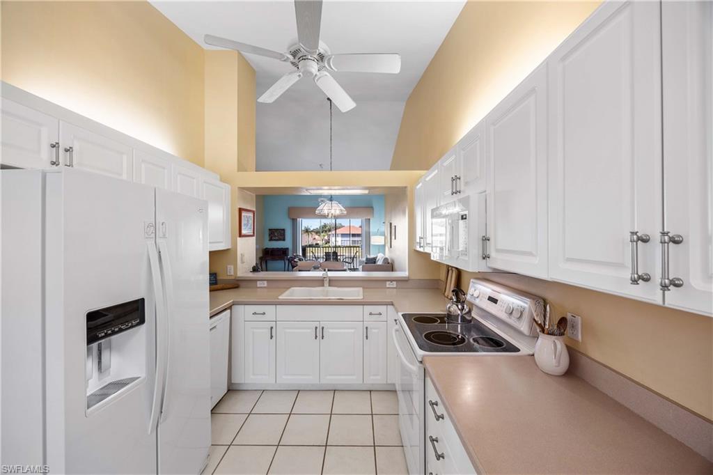 290 Robin Hood Circle, Unit 201 Naples, FL 34104 - Photo 12 of 34 a kitchen with stainless steel appliances a sink a stove a refrigerator and cabinets
