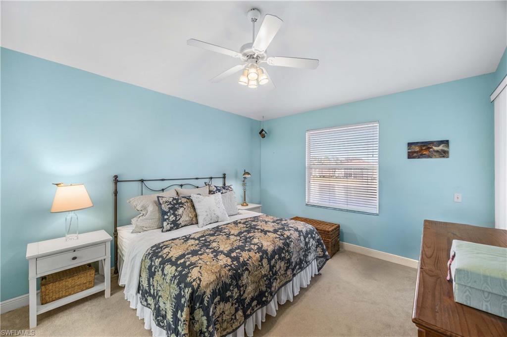 290 Robin Hood Circle, Unit 201 Naples, FL 34104 - Photo 15 of 34 a bedroom with a bed and a night stand