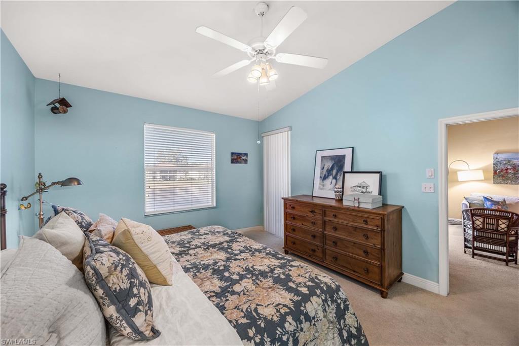 290 Robin Hood Circle, Unit 201 Naples, FL 34104 - Photo 16 of 34 a bedroom with a bed and a chandelier