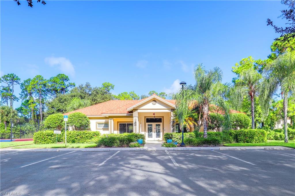 290 Robin Hood Circle, Unit 201 Naples, FL 34104 - Photo 27 of 34 a front view of a house with a garden