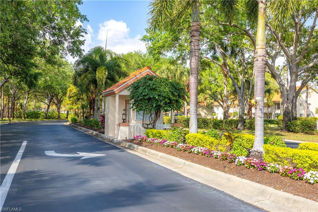 290 Robin Hood Circle, Unit 201 Naples, FL 34104 - Photo 32 of 34 a front view of a house with garden and trees