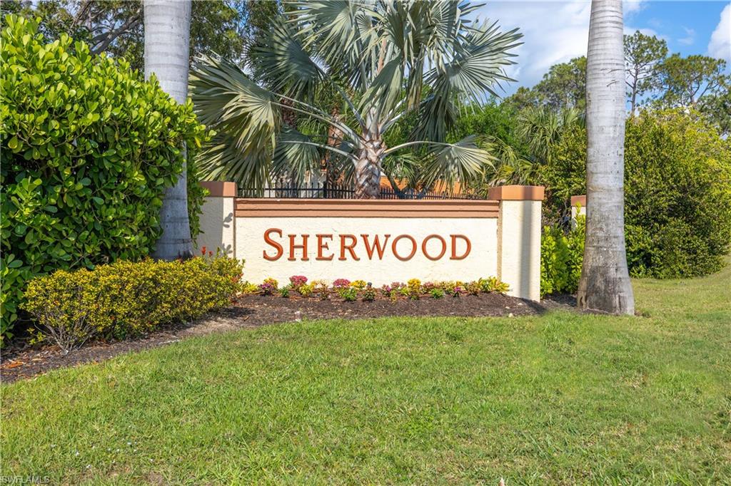 290 Robin Hood Circle, Unit 201 Naples, FL 34104 - Photo 33 of 34 a sign that is sitting in front of yellow house