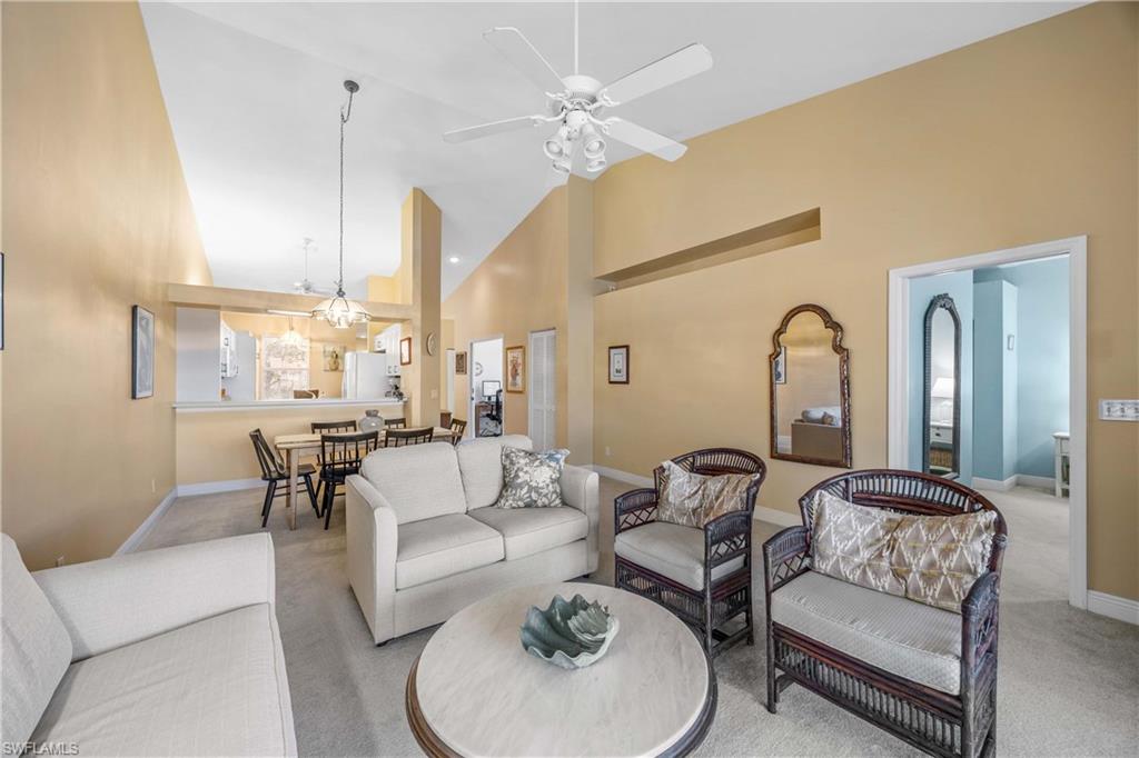 290 Robin Hood Circle, Unit 201 Naples, FL 34104 - Photo 8 of 34 a living room with furniture and a chandelier