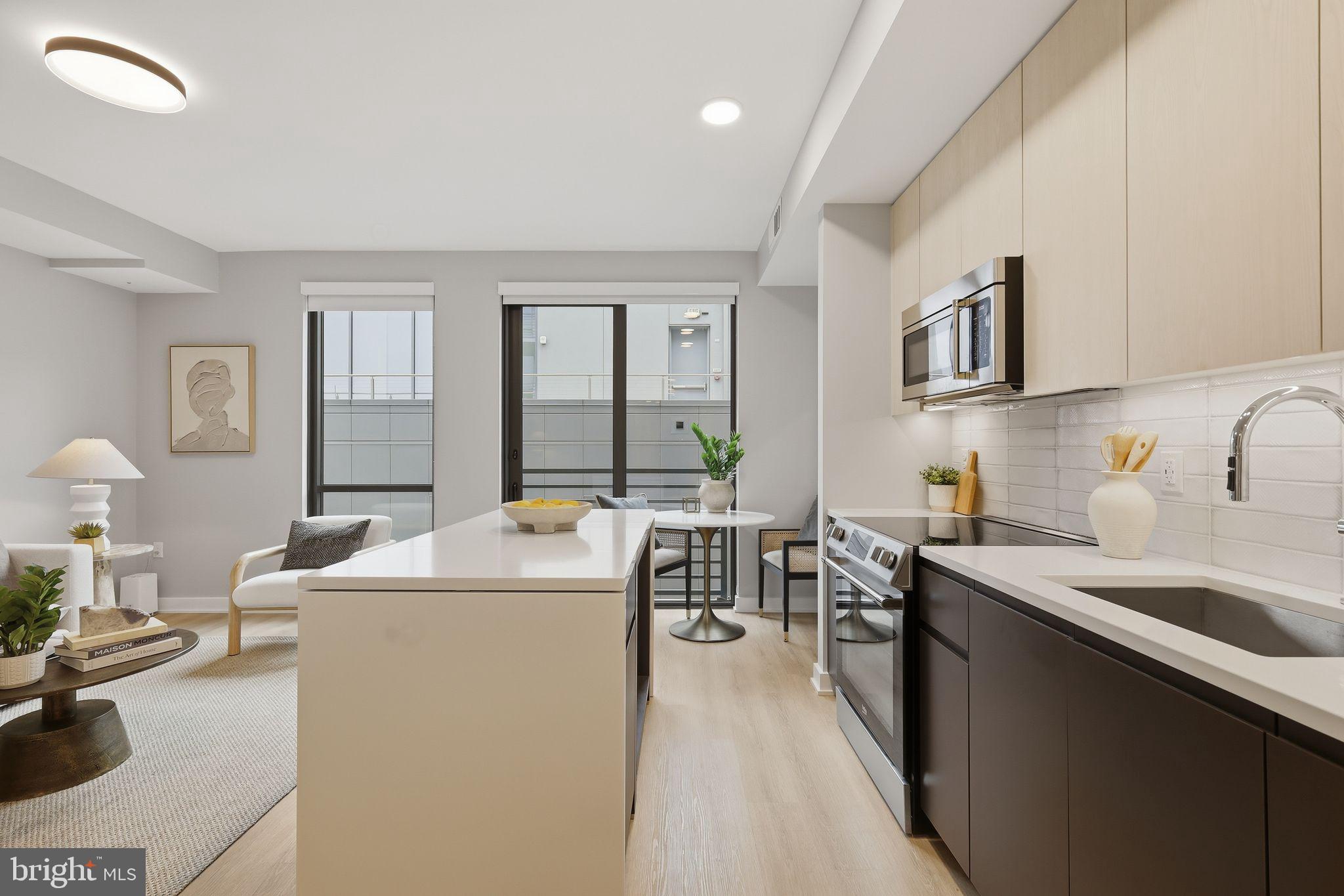 950 3rd Street Northwest, Unit 1009 Washington, DC 20001 - Photo 24 of 32 a view of a kitchen with kitchen island a sink a counter top space and living room view