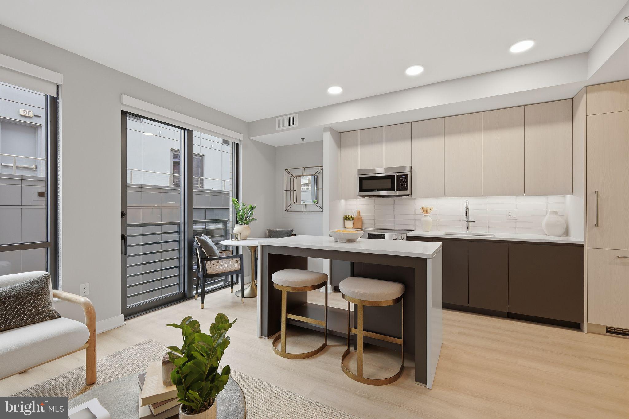 950 3rd Street Northwest, Unit 1009 Washington, DC 20001 - Photo 25 of 32 a kitchen with stainless steel appliances granite countertop a stove a sink a refrigerator a dining table and chairs with wooden floor