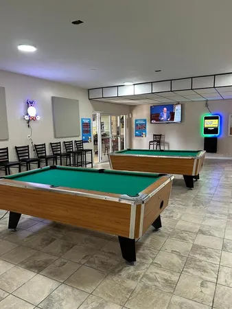 a room with pool table and chairs