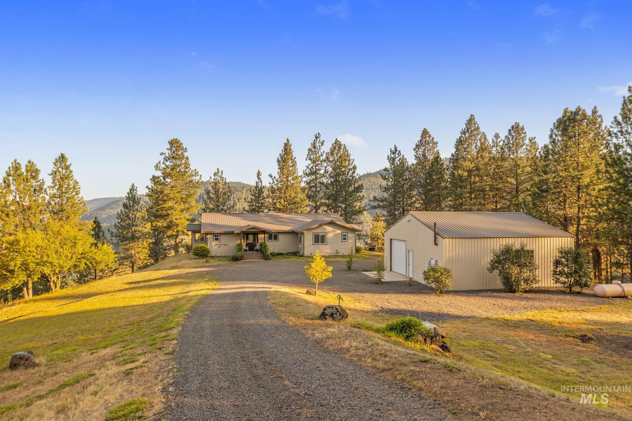 435 River Pointe Lane Lenore, ID 83541 - Photo 3 of 50 Rural property featuring a gravel driveway, a single-story residence with a covered entry, and a separate detached metal building