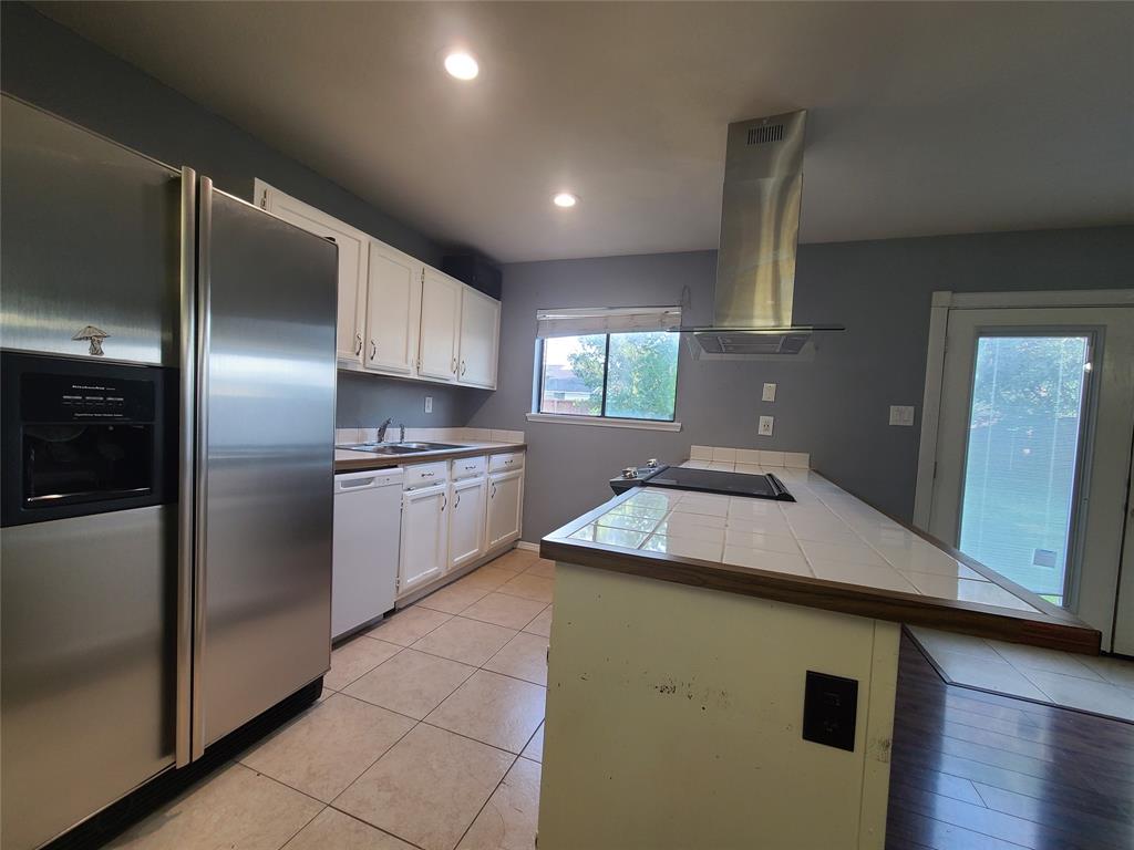 5644 Perrin Street The Colony, TX 75056 - Photo 3 of 16 Kitchen featuring stainless steel refrigerator with ice dispenser, dishwasher, white cabinetry, and ventilation hood