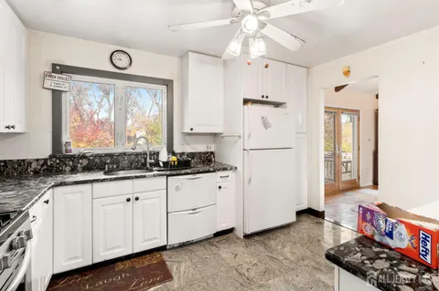 a kitchen with stainless steel appliances granite countertop a sink and a refrigerator