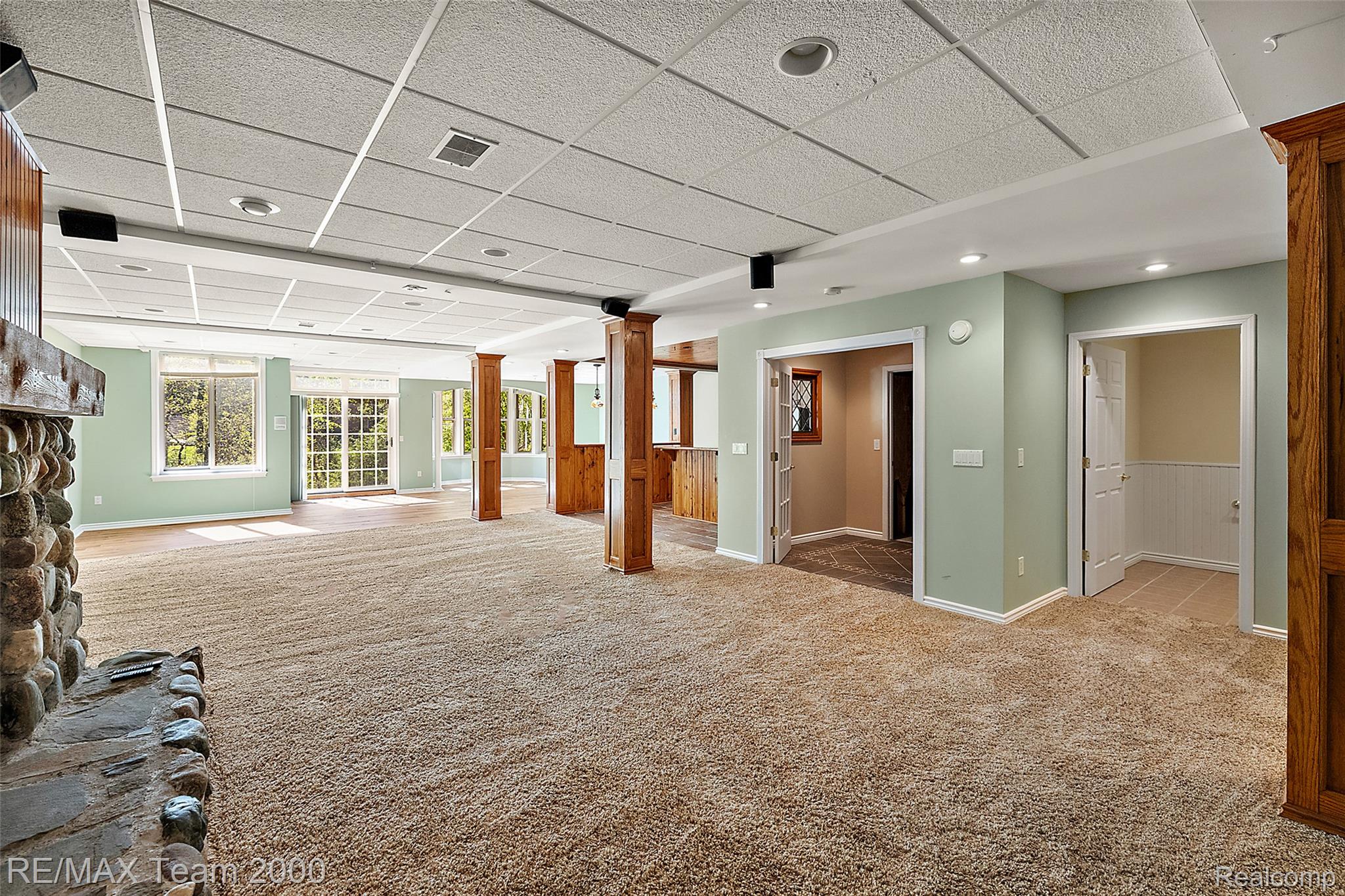 630 Sheldon Court Rochester, MI 48306 - Photo 68 of 94 Unfurnished living room featuring a paneled ceiling, carpet flooring, and decorative columns