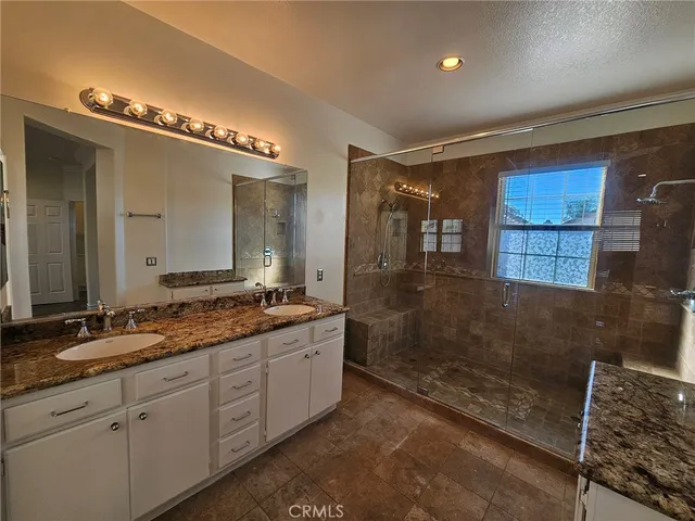 a view of a patio with table and chairs under an umbrella with potted plants