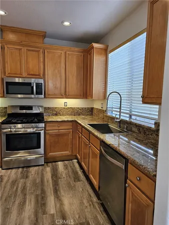 a kitchen with granite countertop a refrigerator stove and microwave