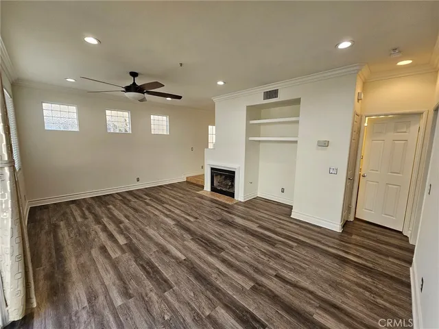 a view of empty room with wooden floor and fireplace
