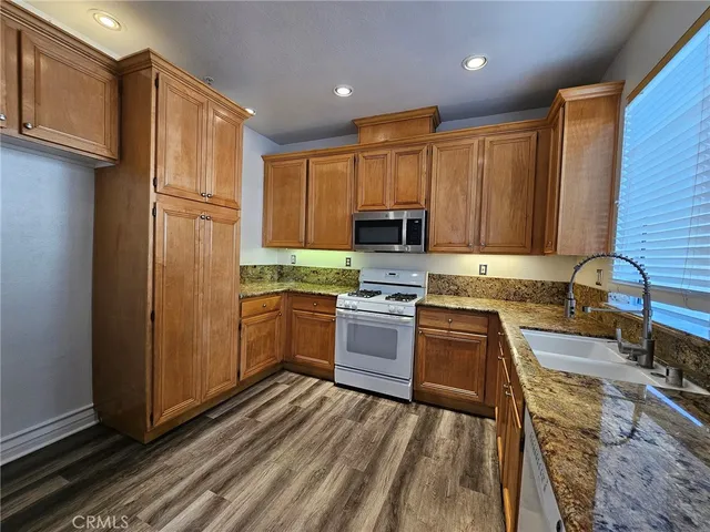 a kitchen with granite countertop stainless steel appliances and wooden cabinets