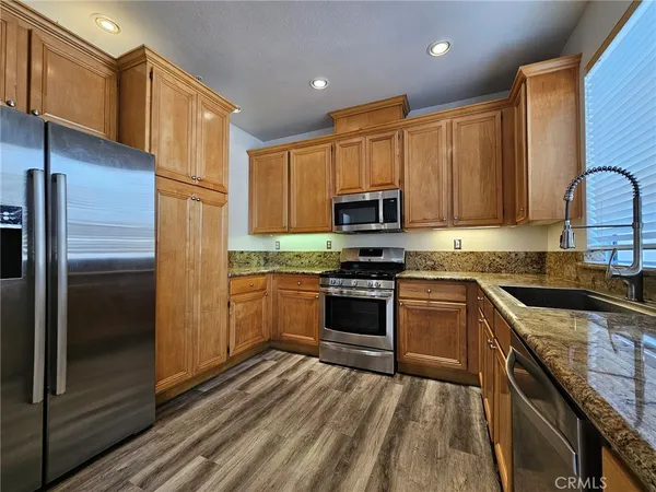 a kitchen with granite countertop cabinets stainless steel appliances and wooden cabinets