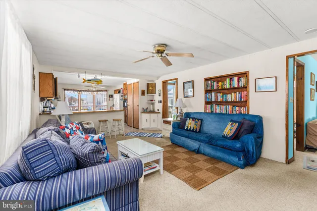 a living room with furniture ceiling fan and a window