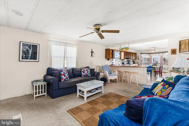 a living room with furniture and view of kitchen
