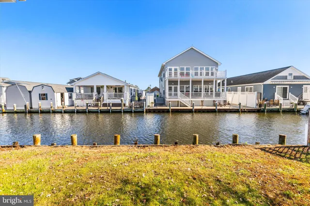 a view of a house next to a lake with houses