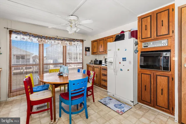 a kitchen with stainless steel appliances a stove a refrigerator a dining table and chairs